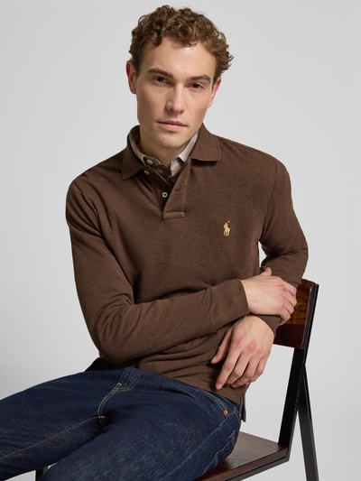 Männermodel trägt Slim Fit Poloshirt aus reiner Baumwolle von Polo Ralph Lauren, braun, unifarben, Piqué-Struktur, Ganzkörperansicht von vorne.