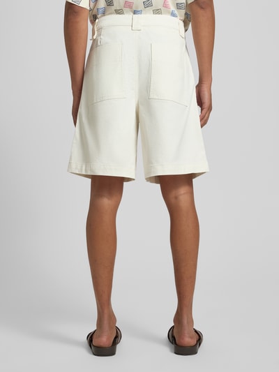 Mężczyzna nosi Loose Fit Bermudas aus Bio-Baumwoll-Mix Modell 'HOTEL AMOUR' von SELECTED HOMME w kolorze jednolitym, denim, naszywka z logo, 5 kieszeni, szlufki na pasek, zapięcie na guzik i kryty zamek błyskawiczny, widok całej sylwetki z tyłu.