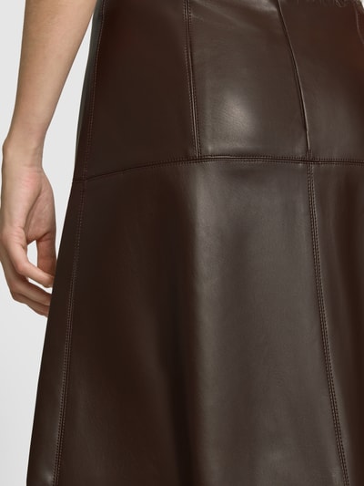Vrouwenmodel draagt midirok in leerlook van Apricot, donkerbruin met siernaden, naadritssluiting, detailopname, Bandwijdte maat S: 36 cm, totale lengte maat S: 78 cm