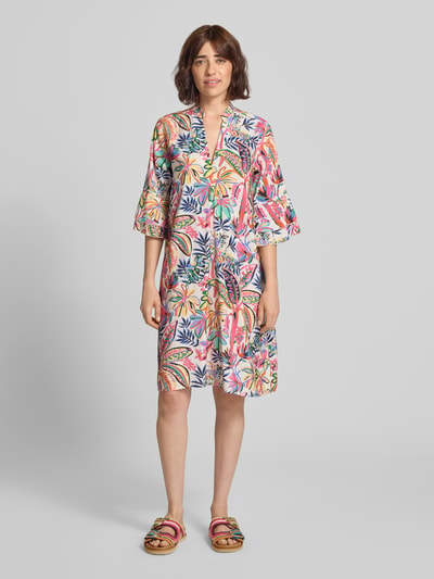 Frauenmodel trägt Relaxed Fit Hemdblusenkleid aus Viskose-Mix von Milano Italy mit floralem Allover-Print, Tunika-Ausschnitt, Halbarm, Ganzkörperansicht von vorne.