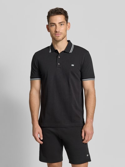 Männermodel trägt Regular Fit Poloshirt mit Kontraststreifen von Christian Berg Men aus Reine Baumwolle, Knopfleiste, Ganzkörperansicht von vorne.