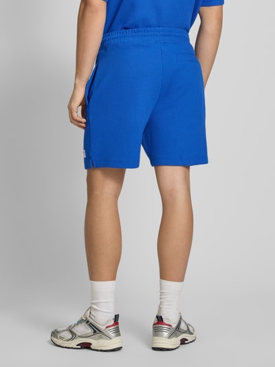 Männermodel trägt Regular Fit Sweatshorts aus Baumwoll-Mix Modell 'NUWAFFLO' von HUGO, Optik: Unifarben, Gesäßtasche, Ganzkörperansicht Rückansicht.
