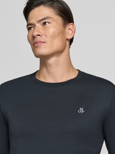 Männermodel trägt Shaped Fit Langarmshirt aus reiner Baumwolle von Marc O'Polo in Dunkelblau mit glatter Textur, Nahaufnahme Oberkörper.