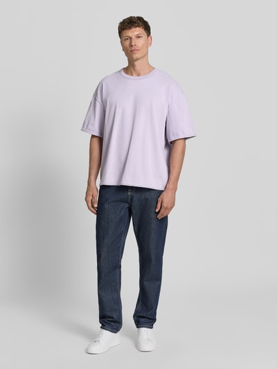 Männermodel trägt T-Shirt mit überschnittenen Schultern Modell 'FAZY' von American Vintage, locker geschnitten, helle Baumwolle, Ganzkörperansicht von vorne.
