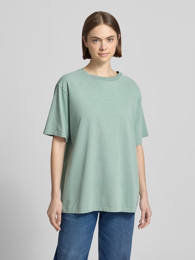 Frauenmodel trägt Oversized T-Shirt mit Label-Stitching von OH APRIL aus Reine Baumwolle, Rundhalsausschnitt, Ganzkörperansicht von vorne.
