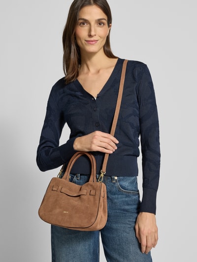 Frauenmodel trägt Handtasche aus Leder mit Label-Detail Modell 'JILL' von Abro in Braun, dazu Jeans und dunkelblauer Cardigan, Nahaufnahme Oberkörper. Handtasche mit Magnetverschluss, Tragehenkel und Schulterriemen, Maße 24x18x11 cm, Riemen 125 cm.