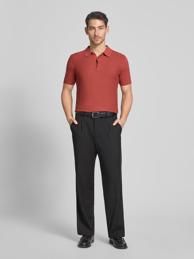 Männermodel trägt Regular Fit Poloshirt aus reiner Baumwolle von Strellson in Strickoptik, Struktur-Muster, Polokragen, V-Ausschnitt, kurze Knopfleiste, Kurzarm, Ärmelabschluss und Rumpfabschluss gerippt, Materialverarbeitung Feinstrick, Farbe Rostrot, schwarze Hose, Ganzkörperansicht von vorne.