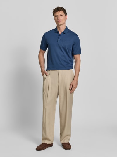 Männermodel trägt Regular Fit Poloshirt mit Brusttasche und Label-Stitching von bugatti, Blau, Polokragen, Knopfleiste, Ganzkörperansicht von vorne. Herren Poloshirt, Rückenlänge bei Größe M: 70 cm.