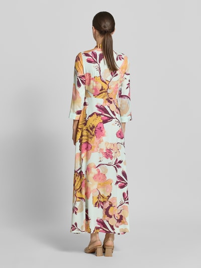 Modelka nosi Hemdblusenkleid aus Viskose mit Knopfleiste Modell 'SAVANNA' od YAS, kolorowy wzór allover, długość maxi, krój A-linia, zdjęcie całej sylwetki z tyłu. Szerokość w rozmiarze S: 47 cm, długość tyłu: 140 cm, długość rękawa: 49 cm.