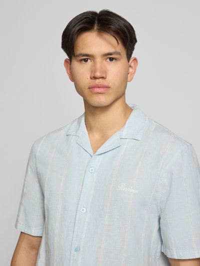 Männermodel trägt Regular Fit Freizeithemd aus Baumwoll-Leinen-Mix mit Reverskragen von REVIEW, hellblau, Label-Stitching, Nahaufnahme Oberkörper.