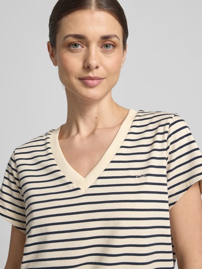 Frauenmodel trägt T-Shirt mit V-Ausschnitt Modell 'Kala' von MOS MOSH, Baumwoll-Elasthan-Mix, dunkelblau gestreift, Nahaufnahme Oberkörper.