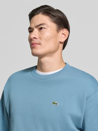 Männermodel trägt Regular Fit Sweatshirt aus Baumwoll-Mix von Lacoste in Hellblau mit Logo, Nahaufnahme Oberkörper, Herren Sweatshirt von Lacoste