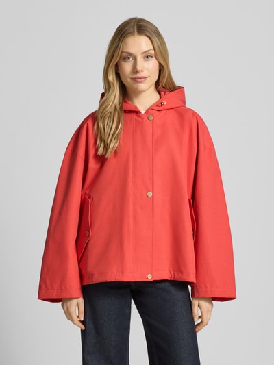 Frauenmodel trägt Jacke mit Kapuze und versiegelten Nähten Modell 'ELLE' von G-LAB in Rot, Lyocell-Mix mit Leinen-Anteil, Gerader-Schnitt, wasserdicht, winddicht, atmungsaktiv, Druckknopfverschluss, seitliche Pattentaschen, Ganzkörperansicht von vorne.