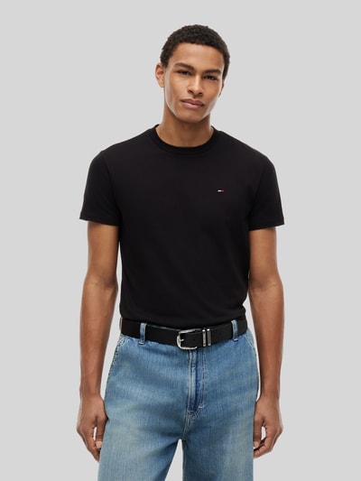Męski model nosi Slim Fit T-Shirts aus reiner Baumwolle im 2er-Pack von Tommy Jeans, efekt: wielokolorowy, krój slim fit, wyhaftowane logo, okrągły dekolt, krótki rękaw, bawełna, Ganzkörperansicht von vorne.
