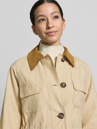 Vrouwenmodel draagt Regular fit functioneel jack van puur katoen model 'CROTON' van Barbour, look: effen, platte kraag, knoopsluiting, labelstitching, waterafstotend, lange mouw, detailopname bovenlichaam.