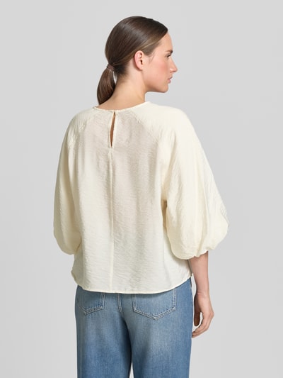 Frauenmodel trägt Regular Fit Bluse aus Viskose-Mix mit 3/4-Arm von Christian Berg Woman, cremefarben, dezente Struktur, Rückenlänge 56 cm, Ganzkörperansicht Rückansicht.