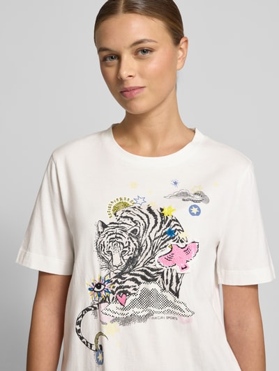 Kobiece modelka nosi T-Shirt mit 1/2-Arm od Marc Cain z czystej bawełny, prosty krój, okrągły dekolt, białe tło, nadruk z tygrysem, detal z logo, widok na górną część ciała z przodu.
