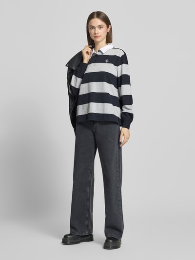 Frauenmodel trägt Polo-Langarmshirt mit Streifen und kontrastiger Knopfleiste von Review aus Baumwolle, Regular Fit, gesticktes Logo, Ganzkörperansicht von vorne