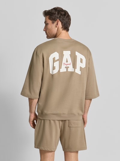 Männermodel trägt T-Shirt mit Rundhalsausschnitt und Logo-Print van GAP van katoenmix in loose fit, logoprint, ribboorden, ruglengte maat M 70 cm, Ganzkörperansicht Rückansicht
