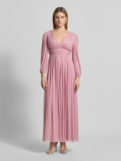 Vrouwenmodel draagt Regular Fit avondjurk in plooien-look van Lipsy in lichtroze, elastische materiaalmix, V-hals, met lange mouwen, elastische mouwboorden, getailleerde pasvorm, ondoorzichtige onderrok, ruglengte maat 36: 135 cm, borstwijdte: 45 cm, mouwlengte: 62 cm. Ganzekijk vanuit voren.