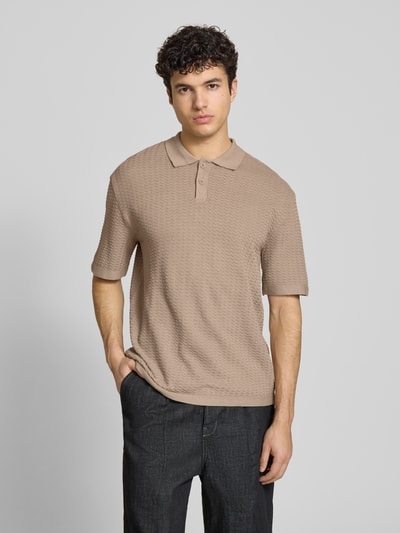 Männermodel trägt Relaxed Fit Poloshirt Modell 'FERDINAND' von Redefined Rebel aus reiner Baumwolle, Strickshirt in Beige, Knopfleiste, Ganzkörperansicht von vorne. Rückenlänge bei Größe M: 70 cm.