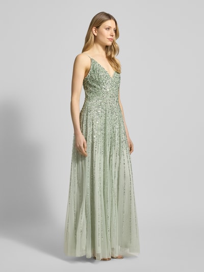 Kobiece modelka nosi Sukienka wieczorowa z cekinowym obszyciem od Lace & Beads z tiulu, taliowany krój, krój bez rękawów, dekolt w serek, wszyty zamek błyskawiczny, długość tyłu w rozmiarze S: 126 cm, szerokość klatki piersiowej w rozmiarze S: 34 cm, jasny zielony kolor, prosta forma i lekka przezroczysta faktura; pełny widok z przodu.