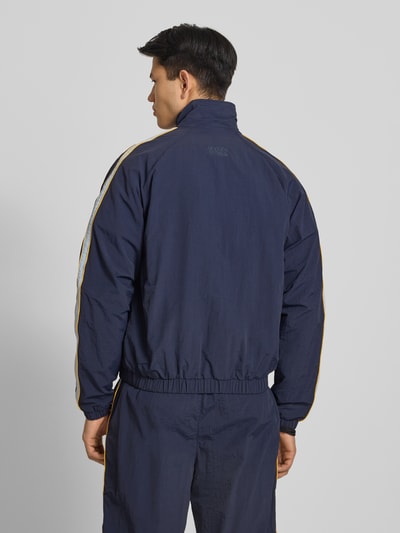 Männermodel trägt Trackjacket mit Label-Stitching Modell 'Slipstream' von PROHIBITED in Dunkelblau, Relaxed Fit, Rückansicht.