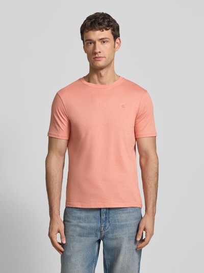 Männermodel trägt Regular Fit T-Shirt mit Logo-Stitching von Scotch & Soda in Rosa aus reiner Baumwolle, Rundhalsausschnitt, Ganzkörperansicht von vorne.