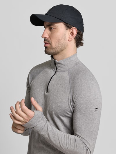 Männermodel trägt graues Langarmshirt mit Troyer Modell 'THE TRAINING DAY QUARTER' von Fabletics, Material-Mix, Nahaufnahme Oberkörper.