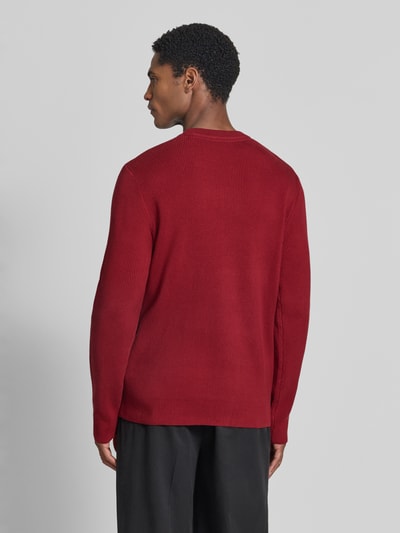 Męski model nosi Slim Fit Strickpullover Baumwoll-Mix od Lindbergh, efekt prążkowania, mieszanka bawełny, okrągły dekolt, długość tyłu 70 cm, długość rękawów 72 cm, Ganzkörperansicht Rückansicht.