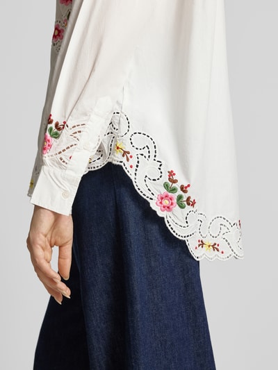 Frauenmodel trägt Modell 'JAYME' von Essentiel Antwerp, weiße Damen Langarmbluse mit floraler Stickerei, Nahaufnahme Oberkörper.
