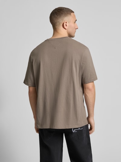 Männermodel trägt Regular Fit T-Shirt aus reiner Baumwolle von Tommy Jeans in Uni-Optik, Webware, kurzarm, Rückansicht, Ganzkörperansicht