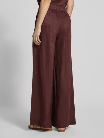 Männermodel trägt Wide Leg Leinenhose mit elastischem Bund Modell 'MOSSI' von ECOALF in Dunkelbraun, reine Leinenstruktur, Ganzkörperansicht Rückansicht, Szerokość w rozmiarze 36: 36 cm, długość wewnętrzna nogawki 79 cm.