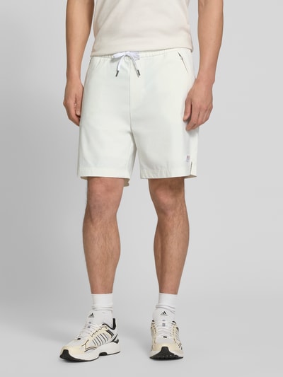 Männermodel trägt Relaxed Fit Sport-Shorts mit seitlichen Reißverschlusstaschen Modell 'Fisher' von BOSS Orange, Optik: Unifarben, Passform: Relaxed-Fit, Tunnelzug, Bundabschluss: Elastisch, Taschen: seitliche Reißverschlusstasche, helle Farbgebung, glatte Textur, Ganzkörperansicht von vorne.
