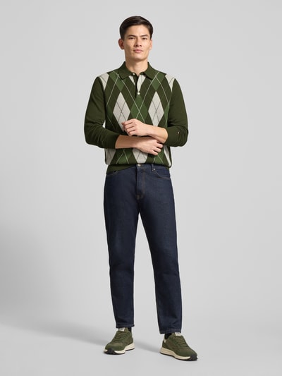 Männermodel trägt Regular Fit Strickpullover aus reiner Baumwolle von Tommy Hilfiger, Optik: Unifarben, Gitterkaro, Polokragen, Langarm, Label-Stitching-Applikation, Materialverarbeitung: Strick, Ganzkörperansicht von vorne.