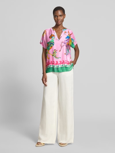 Frauenmodel trägt Blusenshirt aus Viskose im Allover-Look von Milano Italy in Pink und Grün, Regular-Fit, V-Ausschnitt, Ganzkörperansicht von vorne, Rückenlänge 64 cm, Ärmellänge 20 cm bei Größe 36.