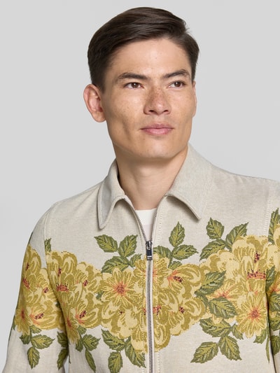 Männermodel trägt Strickjacke mit Kentkragen von Drykorn im Material-Mix und Gerader-Schnitt mit Reißverschluss, Nahaufnahme Oberkörper.