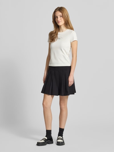 Kobiece modelka nosi czarną spódnicę mini z mieszanki bawełny, model 'Nalham_B' od Hugo Blue, przód, widok całej sylwetki.