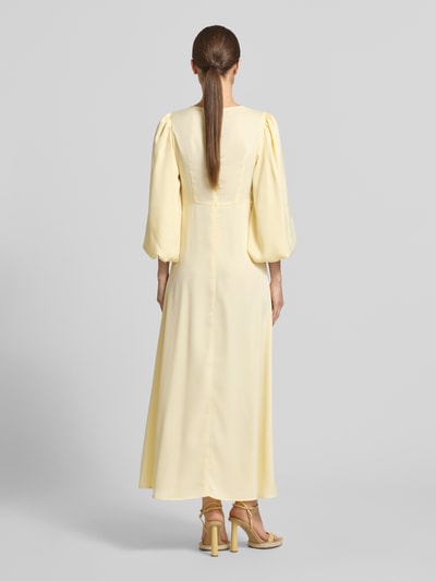 Frauenmodel trägt Maxikleid mit Ballonärmeln Modell 'THEA' von YAS, Material-Mix mit Stretch-Anteil, taillierter Schnitt, Rückenansicht Ganzkörperansicht.