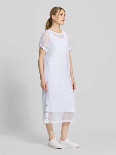Frauenmodel trägt Semitransparentes Midikleid mit Rundhalsausschnitt von Marc Cain im weißen Material-Mix mit Stretch-Anteil, Gerader-Schnitt, lockere Passform, leichte Textur, Semitransparenz, glatte Oberfläche, weiße Farbe, Ganzkörperansicht von vorne. Rückenlänge Größe 36: 115 cm, Brustweite: 58 cm, Ärmellänge: 18 cm.