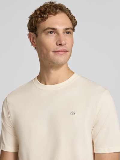 Männermodel trägt Regular Fit T-Shirt aus reiner Baumwolle von Scotch & Soda, dezentes Logo-Stitching, Rundhalsausschnitt, Nahaufnahme Oberkörper. Rückenlänge bei Größe M: 61 cm.