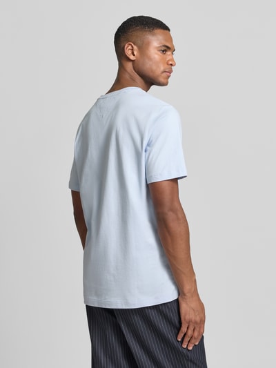 Męski model nosi Regular Fit T-Shirt aus reiner Baumwolle von Tommy Hilfiger, jasno niebieski, krój regular fit, jednolity, logo-stitching, okrągły dekolt, krótki rękaw, jersey, bawełna, widok na całą sylwetkę z tyłu.