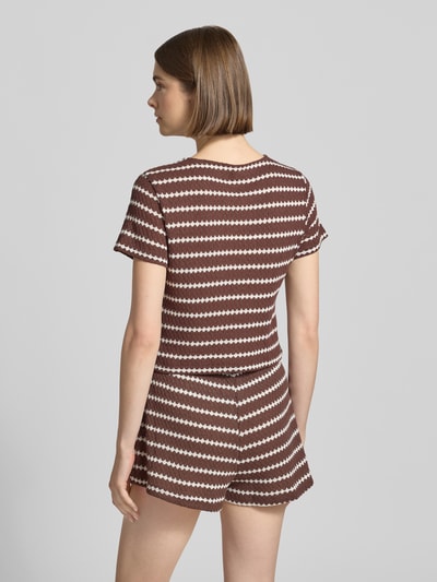 Kobiece model nosi Regular Fit Strick-Shirt mit Baumwoll-Anteil Modell 'EVA' od Only, efekt: wzór na całej powierzchni, okrągły dekolt, krótki rękaw, wiązanie, wykończenie materiału: dzianina, widok całej sylwetki z tyłu.