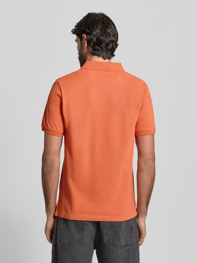 Männermodel trägt Regular Fit Poloshirt aus reiner Baumwolle von s.Oliver RED LABEL in Orange, unifarben, Piqué, Ganzkörperansicht Rückansicht.