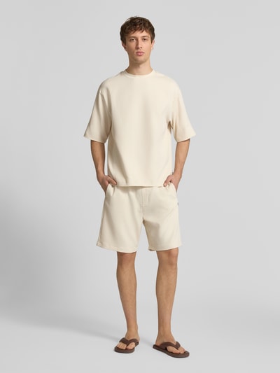 Männermodel trägt Shorts in Plissee-Optik mit elastischem Bund von REVIEW, Material-Mix mit Stretch-Anteil, Regular-Fit, Ganzkörperansicht von vorne.