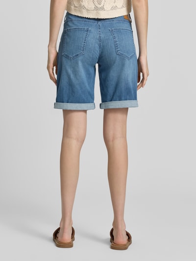 Frauenmodel trägt Bermudas mit Eingrifftaschen Modell 'Summer Clean' von MAC aus Baumwoll-Mix mit Stretch-Anteil in Blau, Ganzkörperansicht Rückansicht.