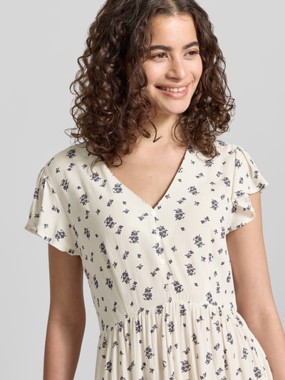 Frauenmodel trägt tailliertes Damen Freizeitkleid von Only, Modell 'CLAUDETTE', Optik: Allover-Muster, V-Ausschnitt, reine Viskose, Nahaufnahme Oberkörper.