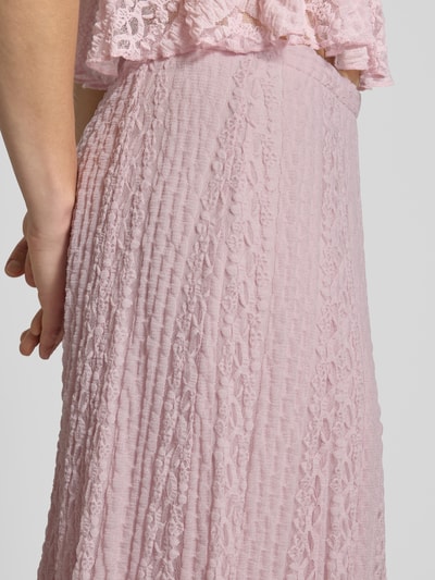 Frauenmodel trägt Maxirock mit Spitze und elastischem Bund von Gina Tricot in Rosa, Material-Mix mit Stretch-Anteil und A-Linie, Detailaufnahme.