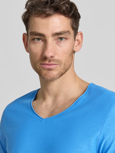 Männermodel trägt Regular Fit T-shirt mit V-hals van MCNEAL, puur katoen, rolzoom, helderblauw, ruglengte maat M 70 cm, nahaufnahme bovenlichaam.