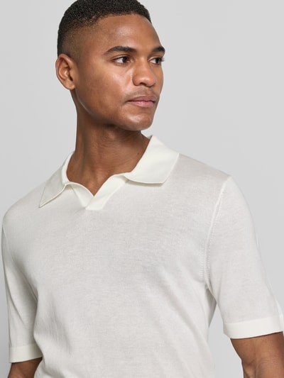 Männermodel trägt 'Slim Fit Poloshirt aus Lyocell-Baumwoll-Mix' von OLYMP Level Five in crème, polokraag, korte mouwen, nahaufnahme oberkörper.